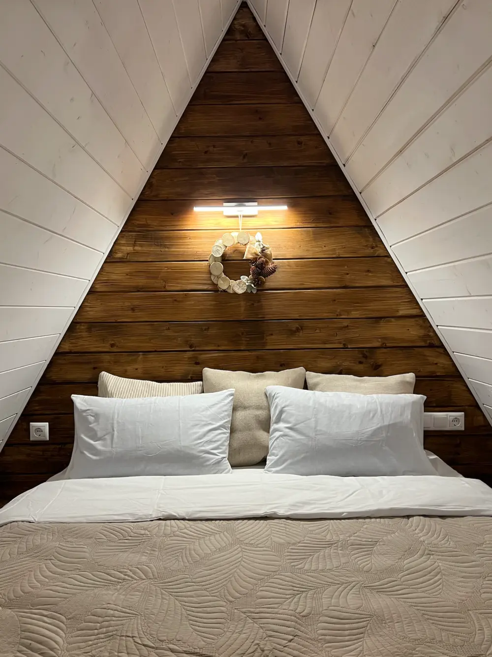 Двуспальная кровать под треугольной крышей A-frame дома