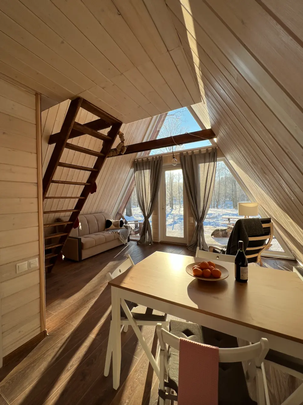 Обеденный стол и лестница в интерьере A-frame дома