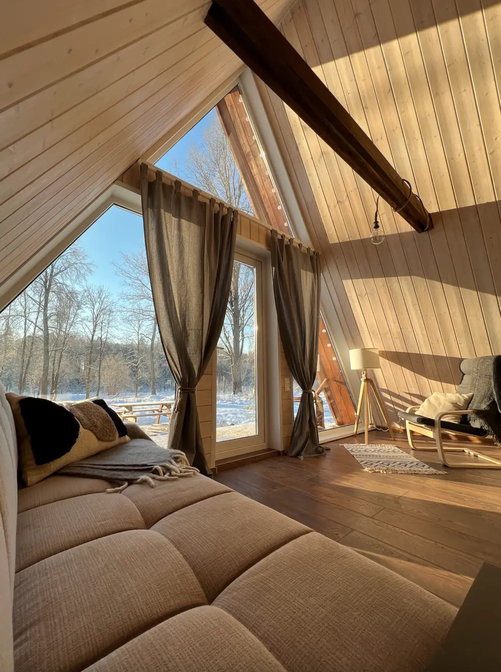 Гостиная с панорамными окнами в A-frame доме Indie House