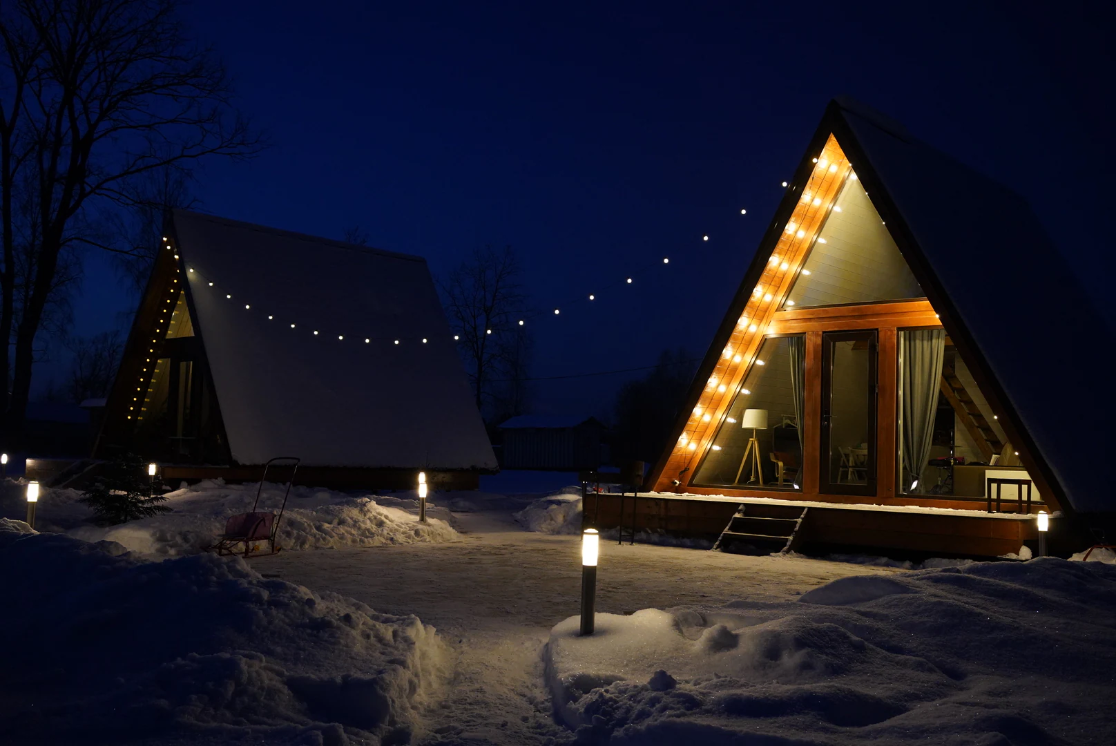 A-frame дома Indie House зимой с тёплой подсветкой
